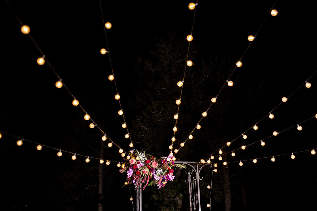 market lights and floral over wedding ceremony