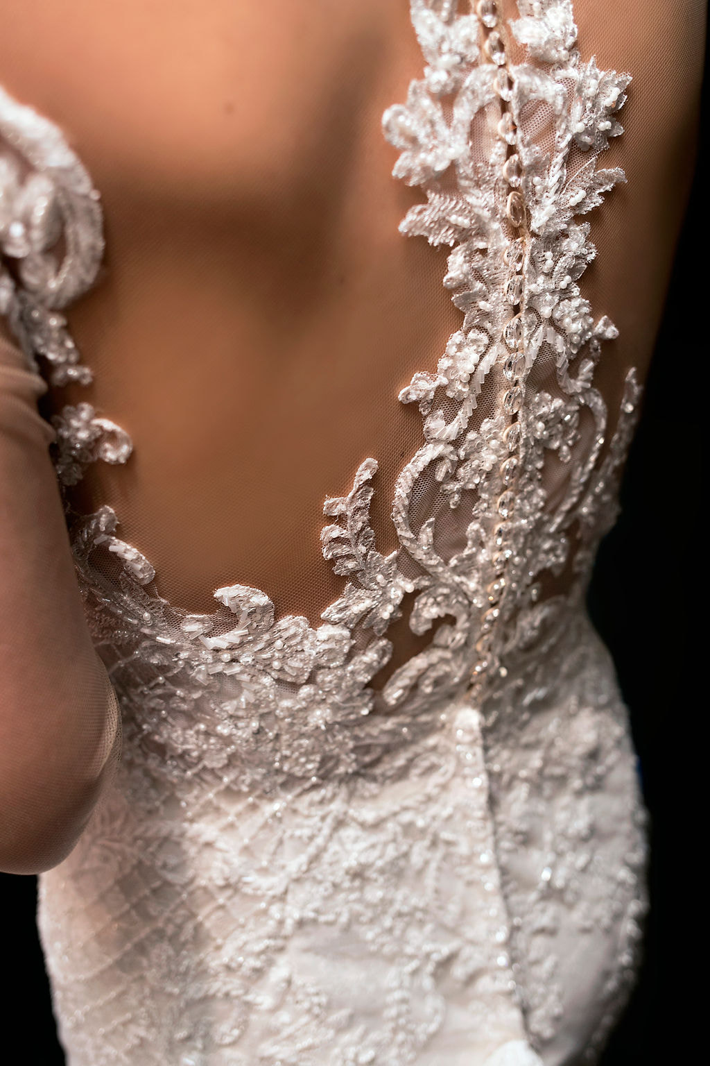 photo of back of bride with lace and beading detail on wedding dress