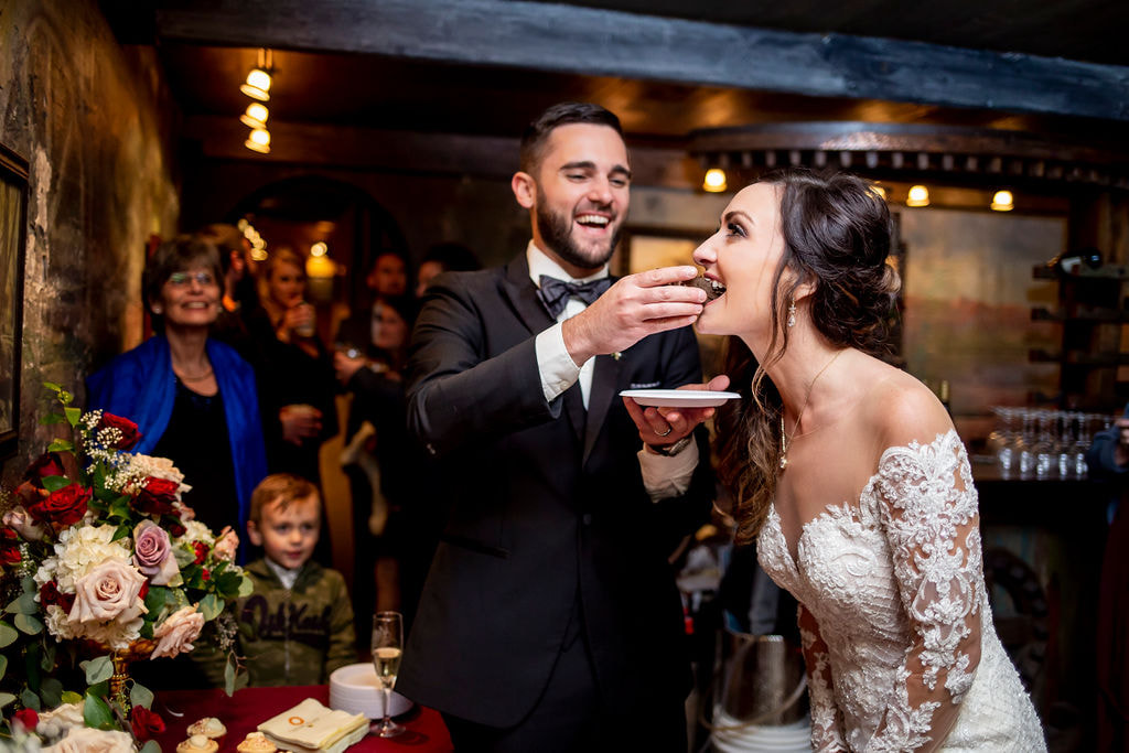 groom feeds bride wedding cake nicely