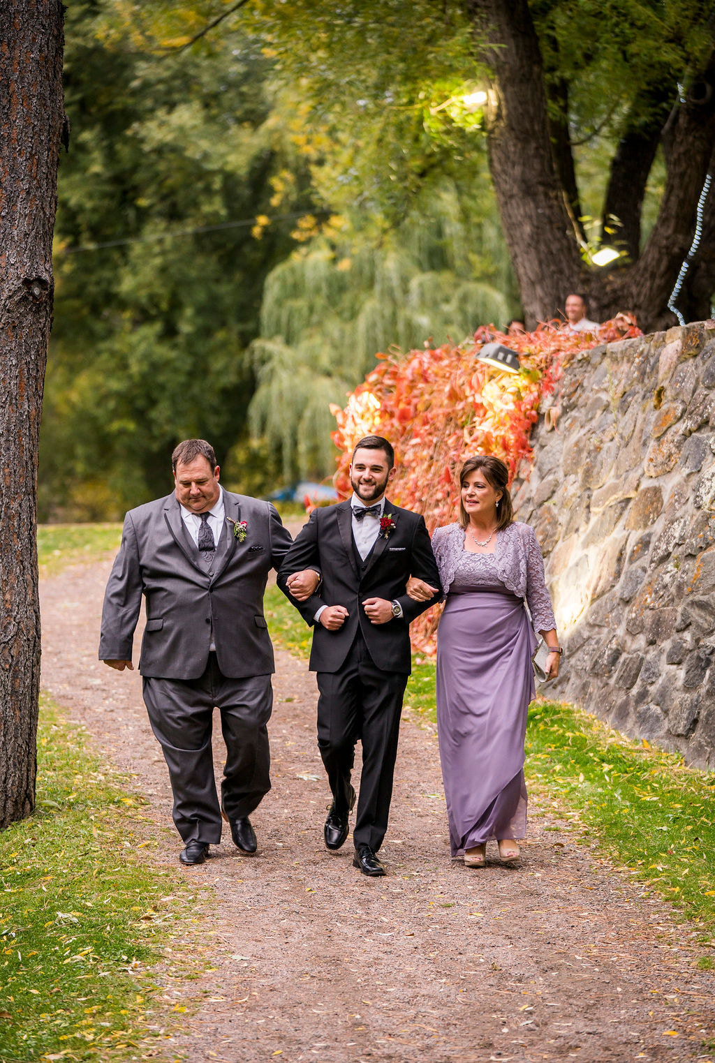 groom walking with both parents down aisle