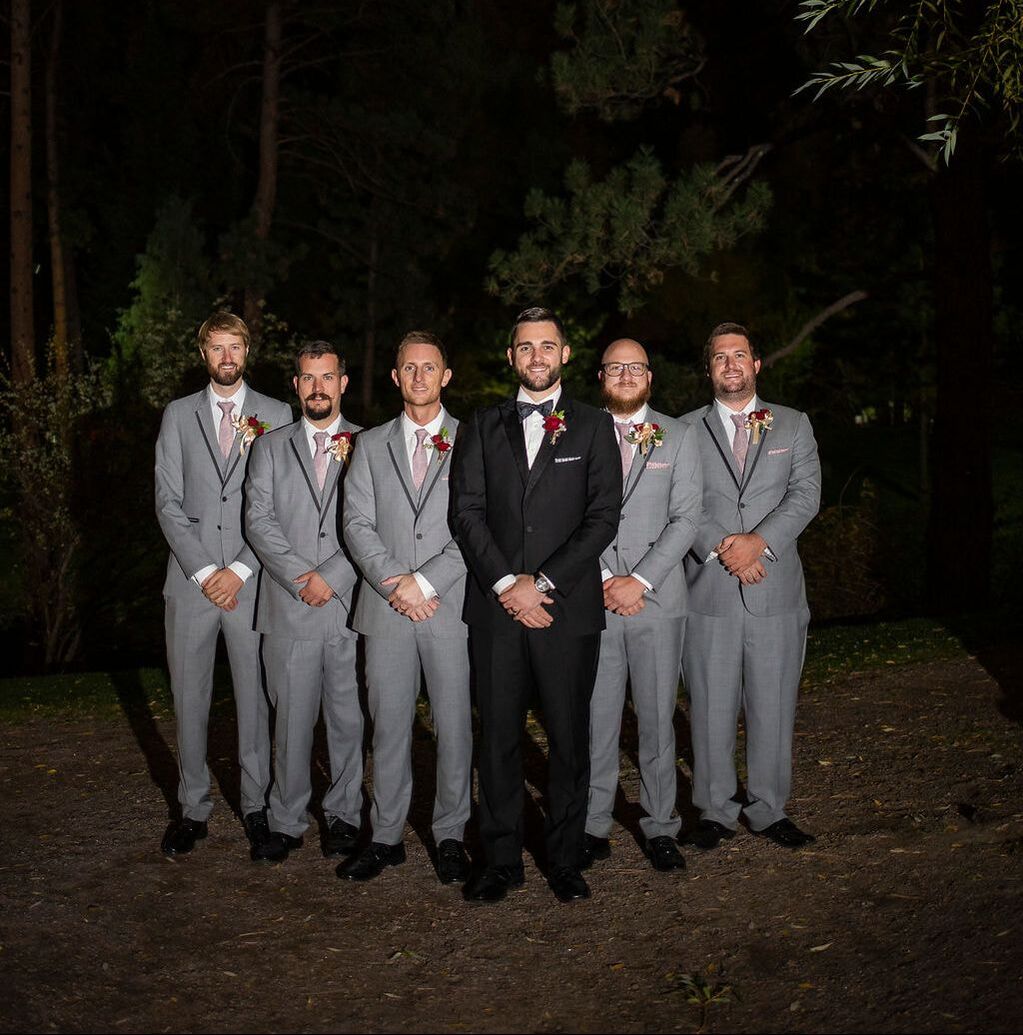 groom in black tux with groomsmen in grey suits