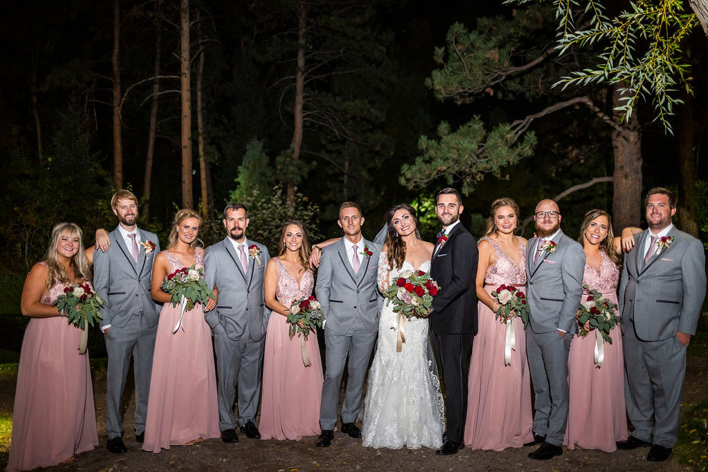 bride and groom with bridesmaids in pink dresses and groomsmend in grey suits