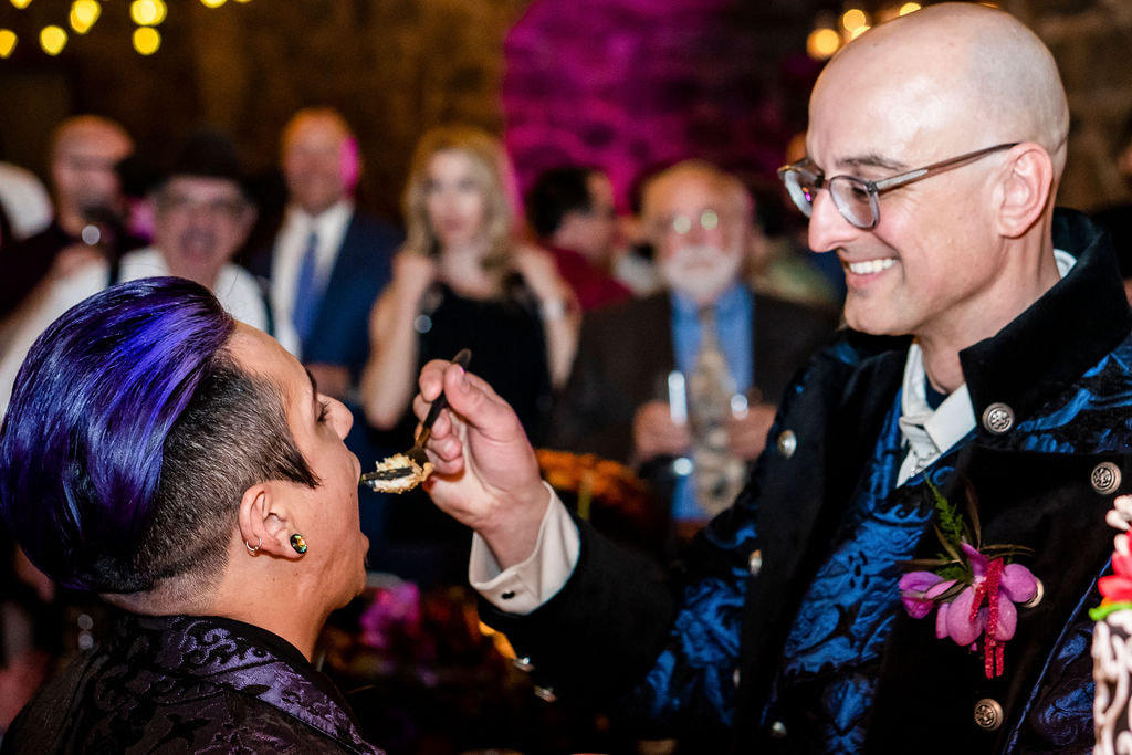 gay wedding couple feeding cake